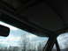 1995 Ford C-350 (Centurion Conversions) - Interior shot showing the vehicle's headliner, visor, and a glimpse of the sky and trees through the windshield.