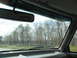 1995 Ford C-350 (Centurion Conversions) - View from inside a vehicle, looking out through the windshield at a wooded landscape.