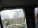 1995 Ford C-350 (Centurion Conversions) - View from the passenger seat of a vehicle, looking out at a landscape of bare trees and distant hills.