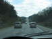 1995 Ford C-350 (Centurion Conversions) - View from inside a vehicle traveling on a highway with trees and hills on either side.