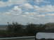 1995 Ford C-350 (Centurion Conversions) - Reflection in the side mirror of a vehicle shows trees and clouds.