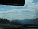1995 Ford C-350 (Centurion Conversions) - View from inside a vehicle traveling through a mountainous region on a cloudy day.