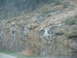 1995 Ford C-350 (Centurion Conversions) - A rocky hillside with trees is visible, likely from a moving vehicle.