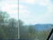 1995 Ford C-350 (Centurion Conversions) - View from the windshield of a vehicle, looking out at a blurry landscape with trees and hills.
