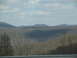 1995 Ford C-350 (Centurion Conversions) - A landscape shot of rolling hills covered in trees, with clouds overhead.