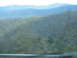 1995 Ford C-350 (Centurion Conversions) - A blurry view of hills and trees suggests a moving vehicle captured this landscape.