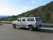 1995 Ford C-350 (Centurion Conversions) - This extended cab pickup truck features a camper shell, giving it a unique, elongated profile against a scenic backdrop.