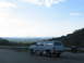 1995 Ford C-350 (Centurion Conversions) - Extended cab pickup truck with camper shell parked on the side of a road with a scenic overlook.