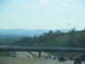 1995 Ford C-350 (Centurion Conversions) - A highway scene with multiple vehicles driving under an overpass on a clear day.