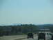 1995 Ford C-350 (Centurion Conversions) - Vehicles travel along a highway under a clear blue sky with distant mountains.