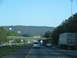 1995 Ford C-350 (Centurion Conversions) - A view from a vehicle traveling on a highway, showing other cars, trucks, and an overpass in the distance.