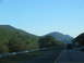1995 Ford C-350 (Centurion Conversions) - View from a car on a highway, with trees and mountains visible.