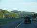 1995 Ford C-350 (Centurion Conversions) - Driving on a highway with trees and hills in the background.