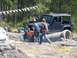 1989 Ford Bronco - A Jeep Wrangler is stuck on a concrete pipe during an off-road event.