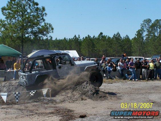 Silver Jeep Wrangler Rubicon kicking up dirt off-road