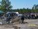 1989 Ford Bronco - A Jeep Wrangler Rubicon navigates an off-road course, with spectators watching in the background.