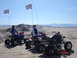 1981 Ford Bronco - Riders on ATVs with checkered flags enjoy a day on the sand dunes.
