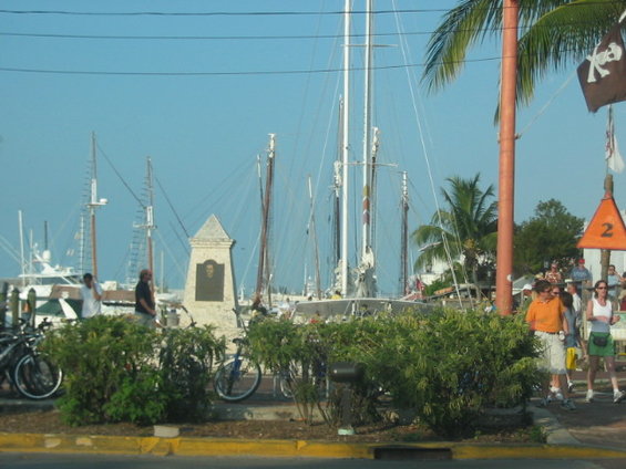 Boats docked in a harbor with people walking nearby