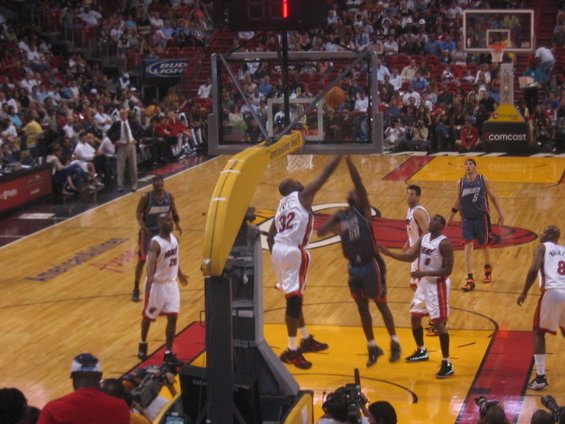 Basketball players in action during a game, with spectators in the background