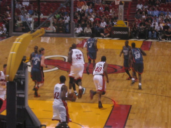 Basketball players in white and blue uniforms on a court during a game