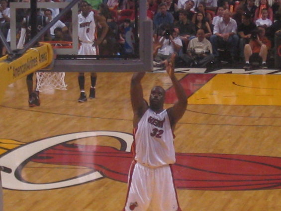 Basketball player in white jersey with number 32 on it, preparing to shoot a free throw. Another player in white jersey with number 6 is visible in the background