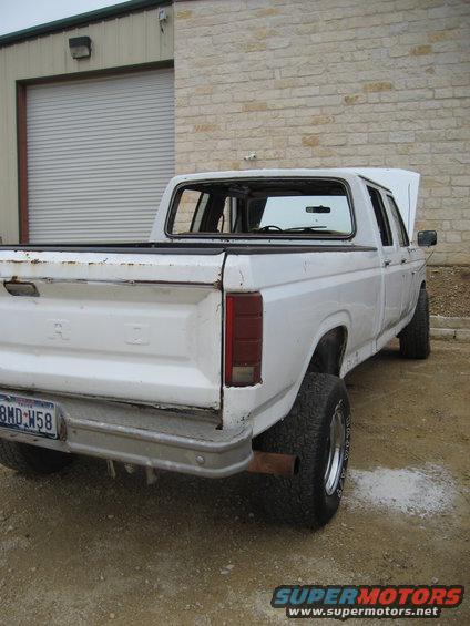 Rear view of a white Ford pickup truck with hood open, license plate 8MD-W58