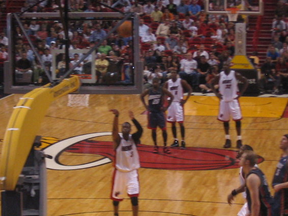 Basketball player shooting a free throw with teammates and crowd in background