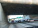 1995 Ford C-350 (Centurion Conversions) - Traffic moves along a highway, passing under a dark overpass with visible water droplets on the windshield.
