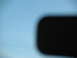 1995 Ford C-350 (Centurion Conversions) - Interior view of a black rearview mirror reflecting the sky.