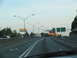 1995 Ford C-350 (Centurion Conversions) - Driving on a multi-lane highway with overhead streetlights and directional signs visible.