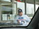 1995 Ford C-350 (Centurion Conversions) - Man in Ford Racing sweatshirt and hat holds cups near a store window with lottery signs.