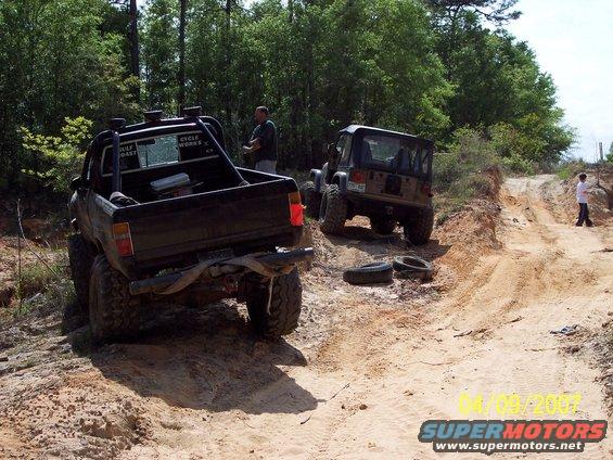 Black 1984 Toyota 4Runner pickup truck with a roll cage, seen from the rear