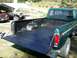 1977 Ford F-150 - The bedliner of a green 1977 Ford F-150 pickup truck is shown, with other vehicles visible in the background.