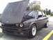 1989 BMW 3 Series - This BMW E30 coupe is shown with its hood open, revealing the engine compartment and aftermarket wheels.