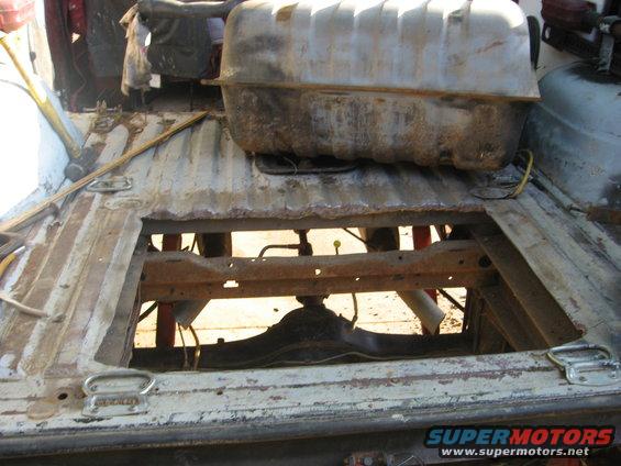 Underside of a vehicle with the fuel tank removed, showing the frame and differential