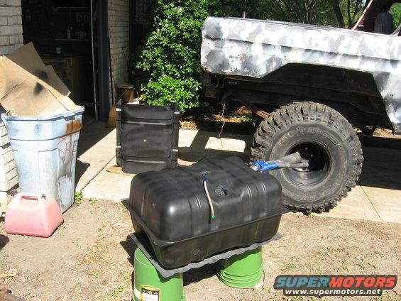 Ford Bronco rear quarter panel, primer finish, large off-road tire, and a new fuel tank on buckets