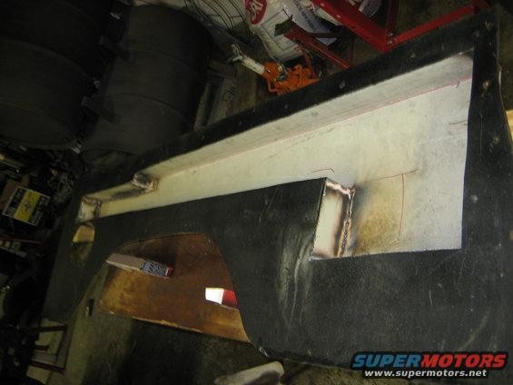 Black car fender with white interior, showing welded metal reinforcement