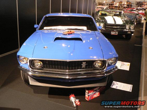 Blue 1969 Ford Mustang front view with a toy car on its hood