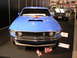 1969 Ford Mustang - A blue 1969 Ford Mustang is displayed at a car show, with another vehicle visible in the background.