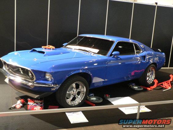 Blue 1969 Ford Mustang coupe with hood scoop and chrome wheels