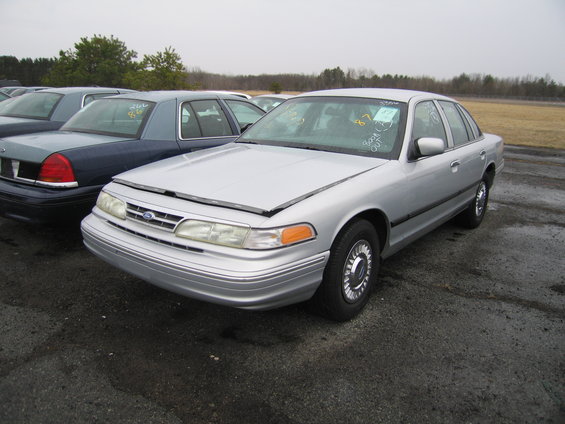 Silver 1991 Ford Crown Victoria LTD with hood open, parked next to a blue car