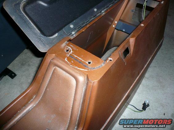Brown vinyl center console with black lid, showing mounting holes and wiring