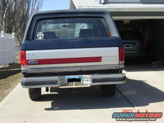 1988 Ford Bronco rear view with Ford logo on tailgate and a second vehicle in garage