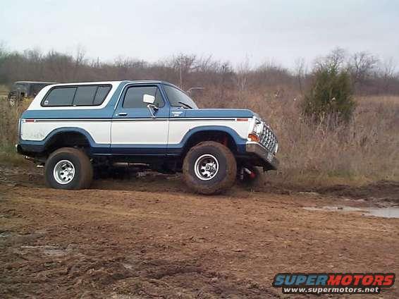 1978 Ford Bronco driving on a muddy trail
