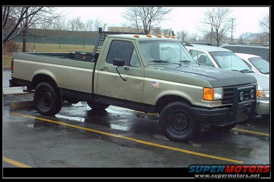 1987 Ford F-250 pickup truck, two-tone green and tan, with a headache rack