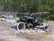 1989 Ford Bronco - A black Jeep Wrangler navigates an obstacle course with concrete pipes in the mud.