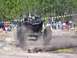 1989 Ford Bronco - An off-road buggy with massive tires powers through a log obstacle course, kicking up dust.