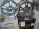 1974 Ford Bronco - Two aftermarket wheels, a silver five-spoke and a chrome multi-spoke, are displayed on top of shipping boxes.
