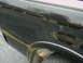 1997 Ford F-150 - Scratched black side panel of a 1997 Ford F-150 with a yellow line and tire visible.
