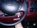 1997 Ford F-150 - The maroon interior of a 1997 Ford F-150 shows a black steering wheel and dashboard details.